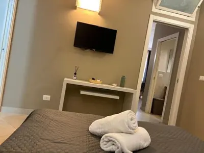 a bedroom with a bed and a tv on the wall at Sikanart Home in Palermo