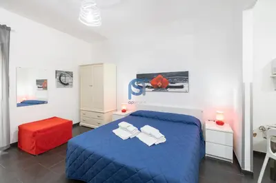 a bedroom with a blue bed and a red stool at Il Vittoria - Self Check in in Lascari