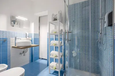 a blue bathroom with a shower and a sink at Palermo of living appartamento Centro Storico in Palermo