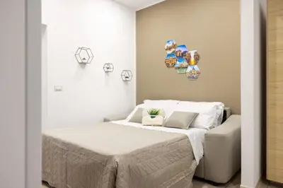 a bedroom with a bed with white sheets at Palermo of living appartamento Centro Storico in Palermo