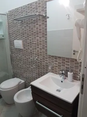 a bathroom with a sink and a toilet and a mirror at B&B Il Sole in Castelluzzo