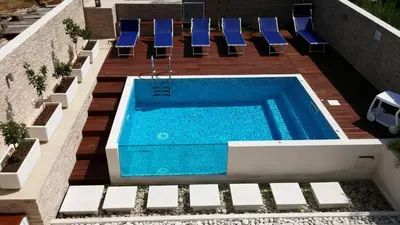 an overhead view of a swimming pool with blue chairs at B&B Il Sole in Castelluzzo