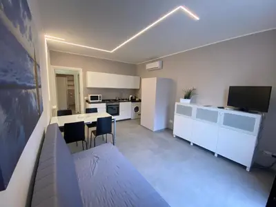 a kitchen with white cabinets and a table and chairs at Casa Penelope in Mondello