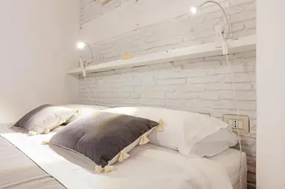 a bedroom with white walls and a bed with pillows at GuestHost - GuestHost - Giusino Experience in Palermo's Heart in Palermo