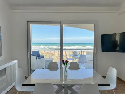 a dining room with a table and a view of the ocean at La perla sulla spiaggia in Alcamo Marina