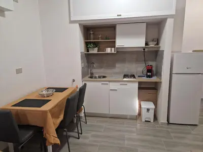 a small kitchen with a table and a refrigerator at Claudio House Palermo in Palermo