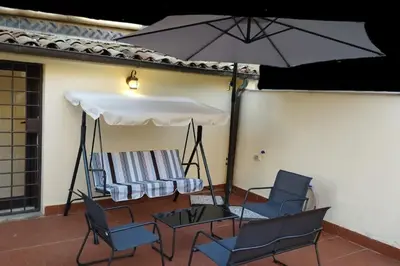 a patio with chairs and a table and an umbrella at Appartamento centro storico.(Nina's house Venezia) in Palermo