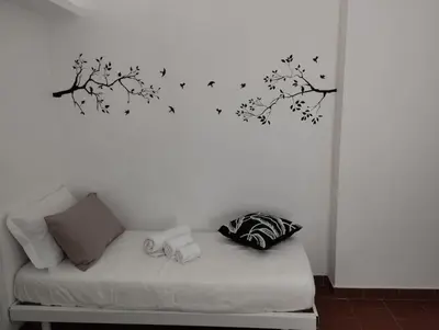 a white wall with a tree with birds on it at Appartamento centro storico.(Nina's house Venezia) in Palermo
