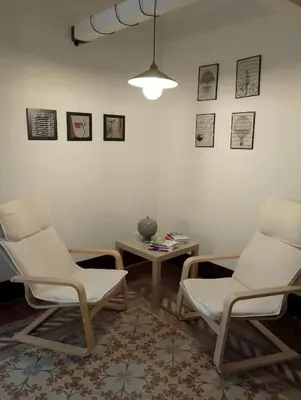 a living room with two chairs and a table at Appartamento centro storico(Nina's house stazione) in Palermo