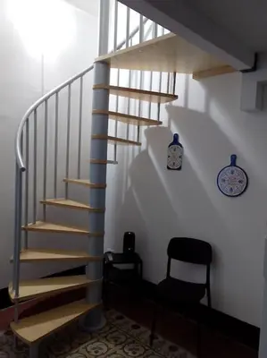 a spiral staircase in a room with a chair at Appartamento centro storico(Nina's house stazione) in Palermo