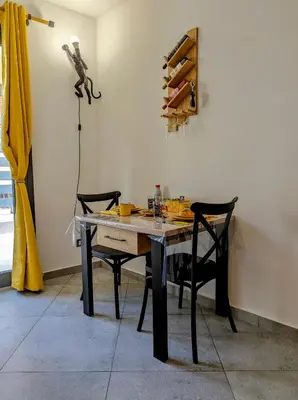 a dining room table with two chairs and a lamp at I colori della Sicilia in Cinisi