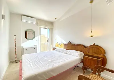 a bedroom with a large bed with a wooden headboard at Solemar Sicilia - Casa Tosca in Ficarazzi