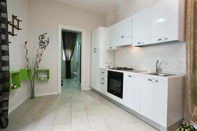 a white kitchen with a sink and a stove at Casa Le Nereidi in Castellammare del Golfo