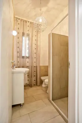 a bathroom with a sink toilet and a chandelier at Casa Le Nereidi in Castellammare del Golfo