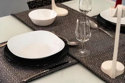a table with a plate and two wine glasses on it at NIKA NIKA Holiday House in Carini