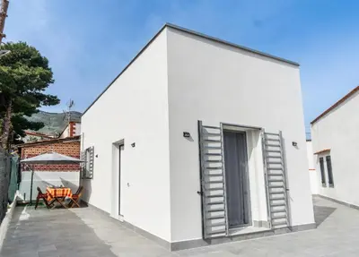 a white house with stairs leading to a patio at NIKA NIKA Holiday House in Carini