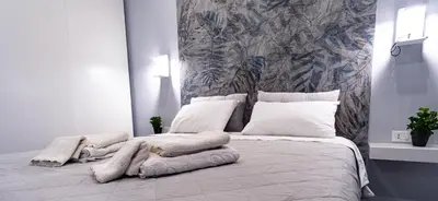 a white bedroom with a large bed with pillows at NIKA NIKA Holiday House in Carini