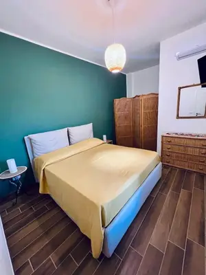 a bedroom with a bed and a green wall at Reef Mondello Apartment in Palermo