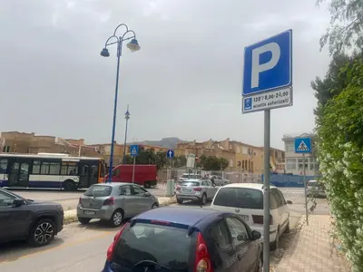 a parking lot with a parking sign and cars parked at Reef Mondello Apartment in Palermo