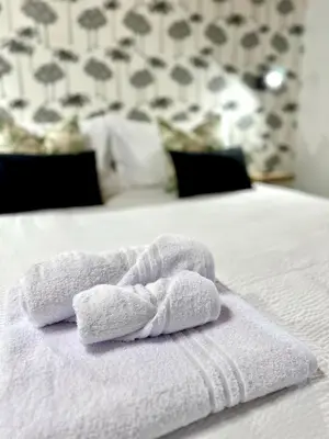 a towel on top of a white bed at 4Rooms in Palermo