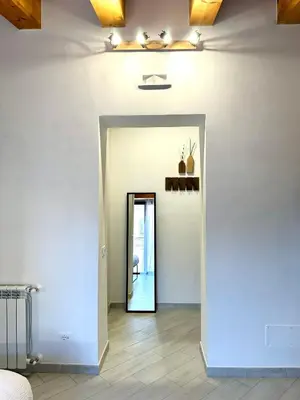 a hallway with a white wall and a doorway at 4Rooms in Palermo