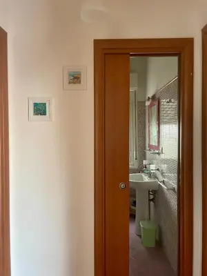 a bathroom with a door leading to a sink at La Villetta di Sofia in Carini