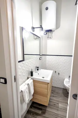a white bathroom with a sink and a mirror at Il Bel Canto - Suite in centro storico in Palermo