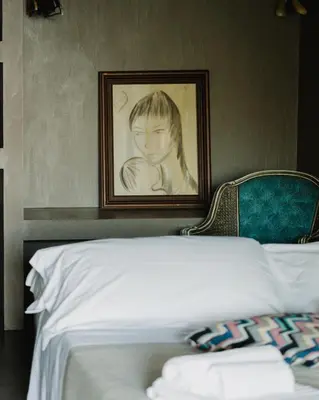 a painting of a child on a wall next to a bed at QUIETE e MARE in San Vito lo Capo