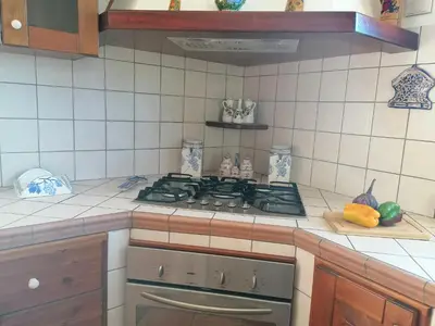 a kitchen with a stove top oven in a kitchen at Villa Francesca in Castelluzzo