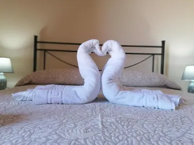 two swan towels are forming a heart on a bed at Villa Francesca in Castelluzzo