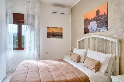 a bedroom with a large bed with white pillows at Vista Mare Rooms in Isola delle Femmine