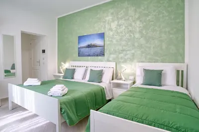 two beds in a room with green and white at Vista Mare Rooms in Isola delle Femmine