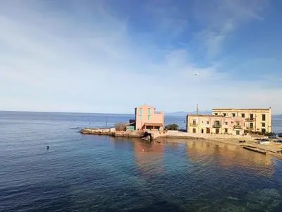 an island in the water with buildings in the background at Casa Vacanze Zafarana in Santa Flavia