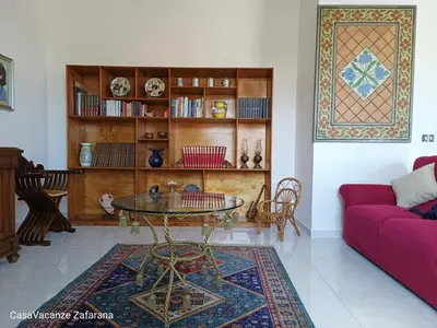 a living room with a table and a couch at Casa Vacanze Zafarana in Santa Flavia