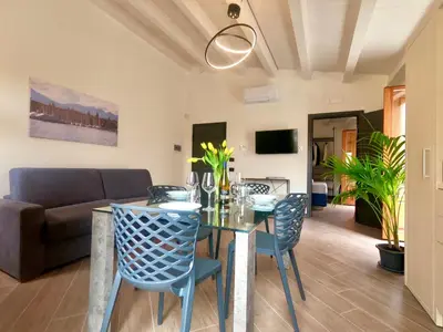 a living room with a table and chairs and a couch at Ponticello Apartments in Palermo