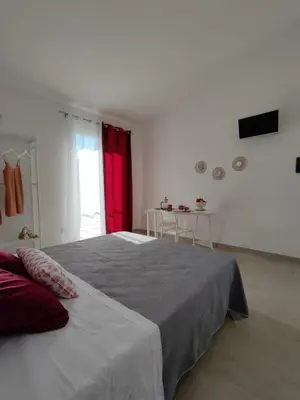 a bedroom with a large bed with a red curtain at Tacco e Punta bed&breakfast in Grisi