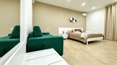a bedroom with a bed and a green couch at ARIA b&b in Terrasini