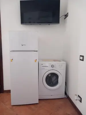 a kitchen with a washing machine and a tv at A casa scalilla 2 in Palermo