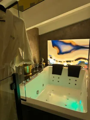 a bath tub in a bathroom with a painting at SantaTeresa19 Suite & Spa in Palermo