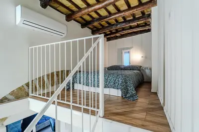 a bedroom with a bed and a staircase at Trabia25 Suite Palermo in Palermo
