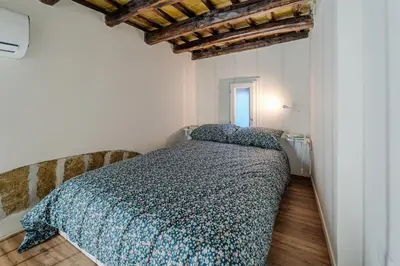 a bedroom with a bed with a blue comforter at Trabia25 Suite Palermo in Palermo