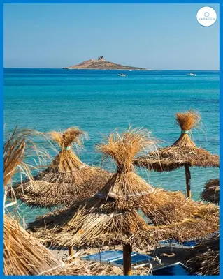 a group of straw umbrellas on the beach at MAESTRALE CASA VACANZA in Isola delle Femmine