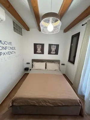 a bed in a room with a ceiling at MAESTRALE CASA VACANZA in Isola delle Femmine