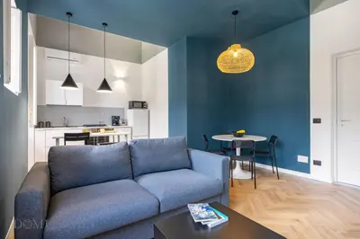 a living room with a blue couch and a table at Real Tenuta Apartments By Domus Sicily in Palermo