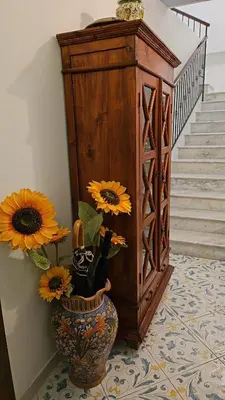 a vase with flowers in it next to a staircase at casa Ennio by Villa Paola Ciminna in Ciminna