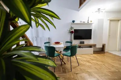 a living room with a table and chairs and a television at Noble Suite in Palermo