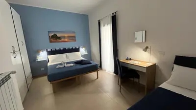a bedroom with a bed and a desk in it at Cuba Holiday House in Palermo