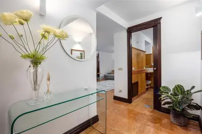 a hallway with a glass table with a vase of flowers at Behind the Cathedral apt in Palermo
