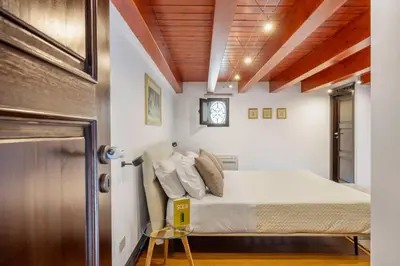 a bedroom with a bed and a clock on the wall at Behind the Cathedral apt in Palermo