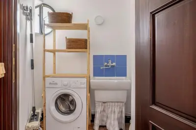 a bathroom with a washing machine and a sink at Behind the Cathedral apt in Palermo